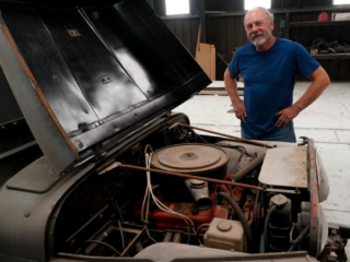 Man standing by a Jeep with the hood raised
